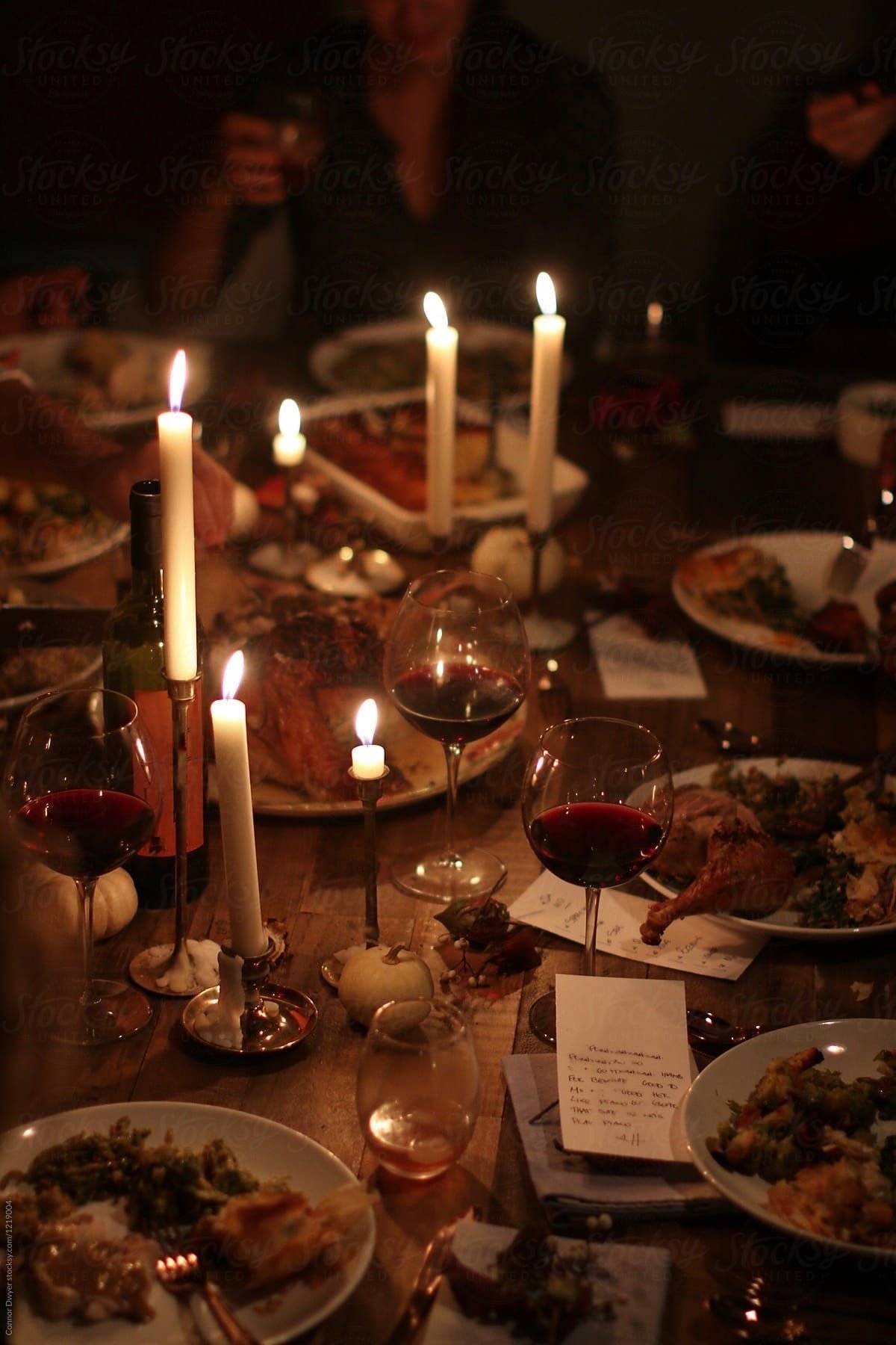 Tall candles burning low over the finished table
