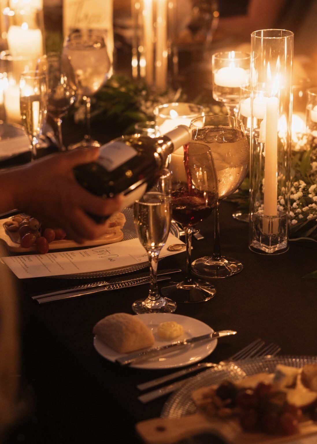 Wine poured by candlelight at the dinner table